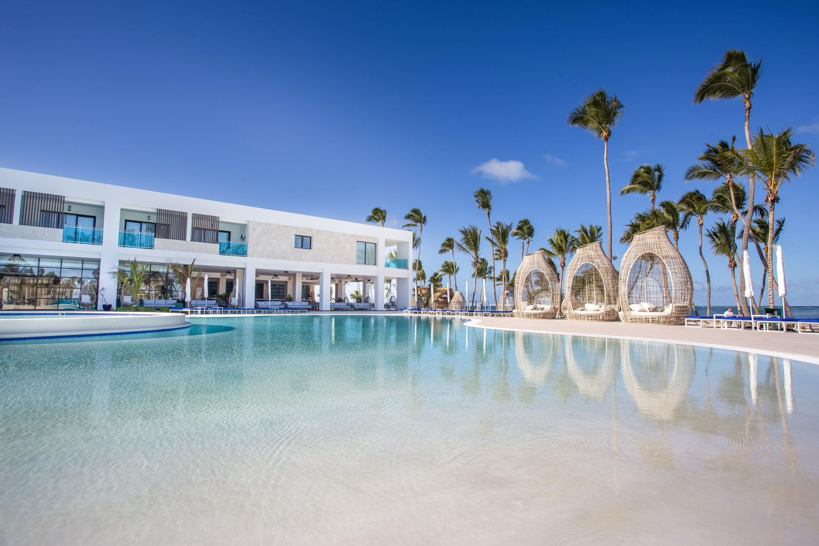 Piscina y palmeras del Hotel Serenade frente al mar en Punta Cana